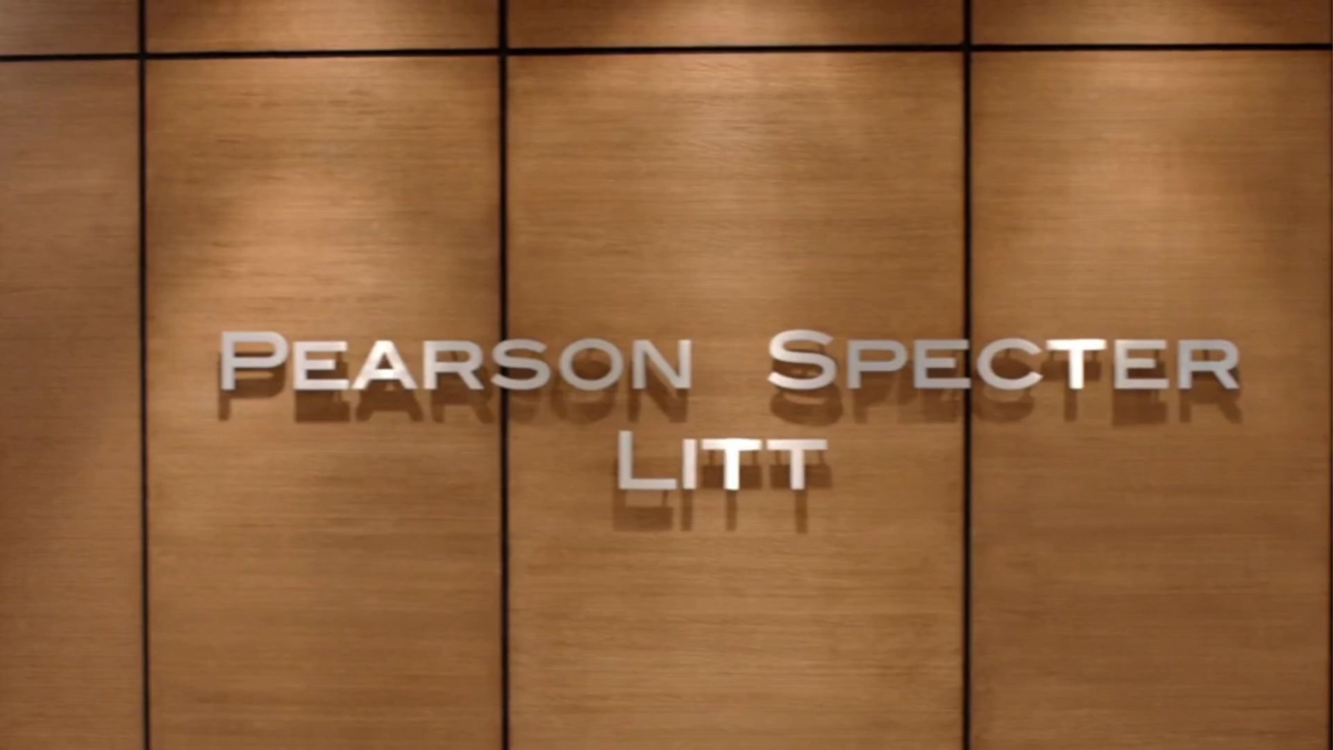 The name board reading &#039;Pearson Specter Litt&#039; from Suits | Image Source: Netflix