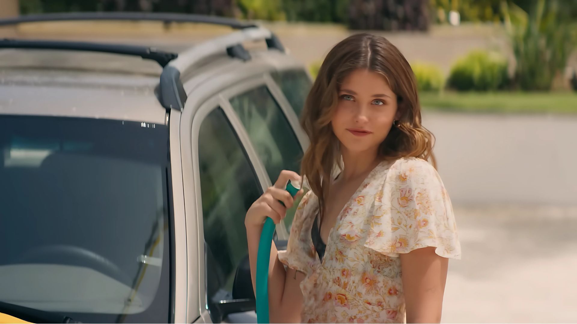 Noah is seen standing beside a car