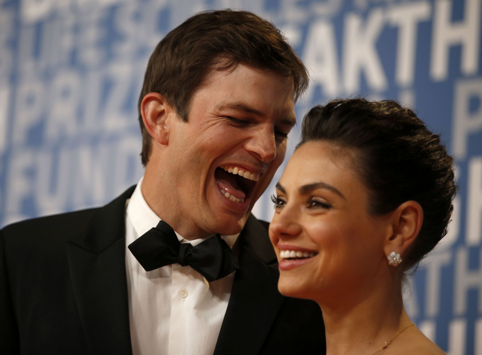 Actor Ashton Kutcher laughs with his wife actress Mila Kunis while posing for pictures on the red carpet for the 6th annual 2018 Breakthrough Prizes at Moffett Federal Airfield, Hangar One in Mountain View, Calif., on Sunday, Dec. 3, 2017. (Nhat V. Meyer/ - Source: Getty