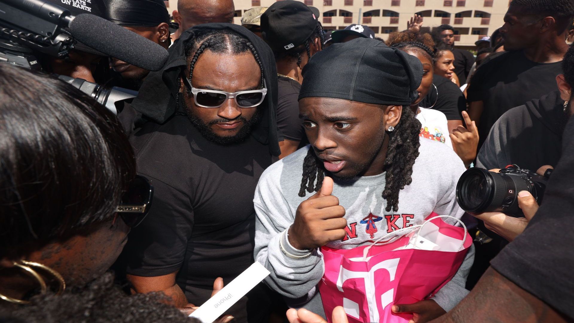 Kai Cenat is swarmed by fans and body guards as he hands out free shoes and iPhones to locals at Gonzales Park on Monday, July 1, 2024 in Compton, CA. (Michael Blackshire / Los Angeles Times via Getty Images)