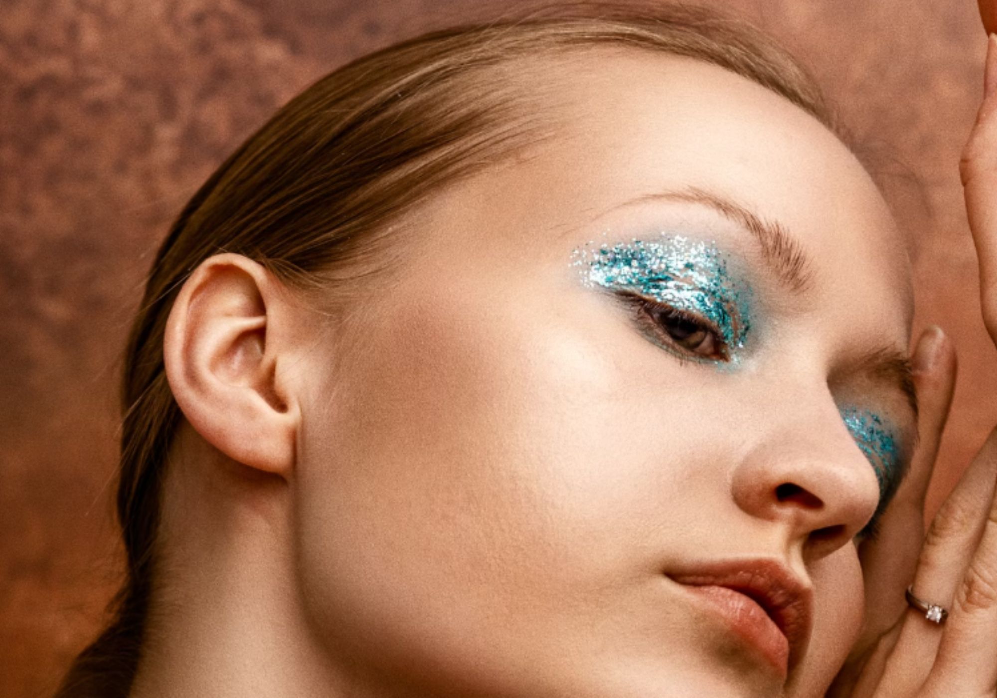 Blue glittery makeup (Image via Unsplash/ Edward Howell)