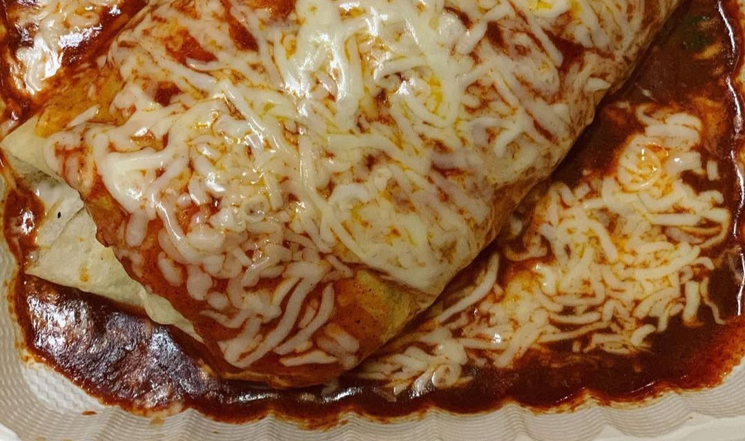 Wet burrito topped with cheese from Tacos Por Favor. (Image via Instagram/@tacosporfavor_inc)