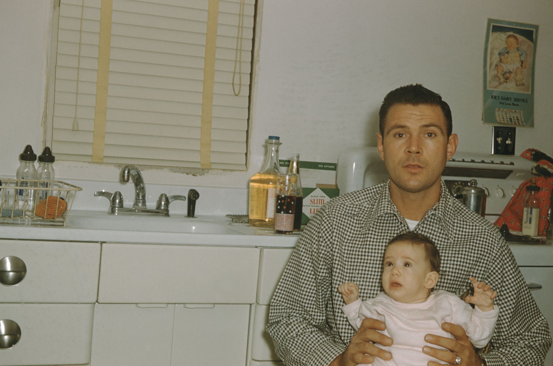 A Man Holding An Infant - Source: Getty