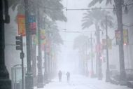 Commuters make their way down a snowy Canal Street on Tuesday (Image via Getty)