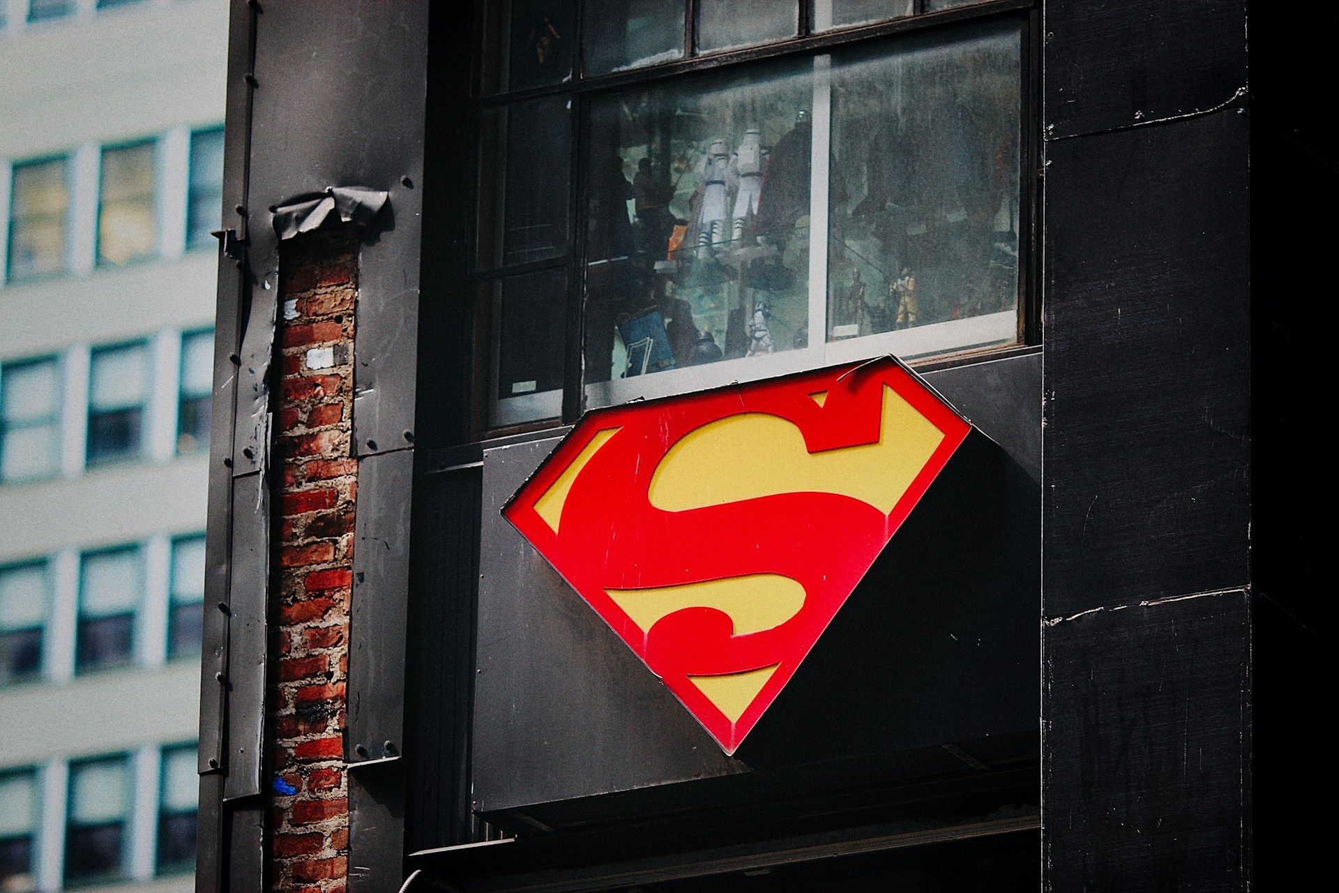 Image of Superman Logo (Image via Unsplash/Jon Tyson)