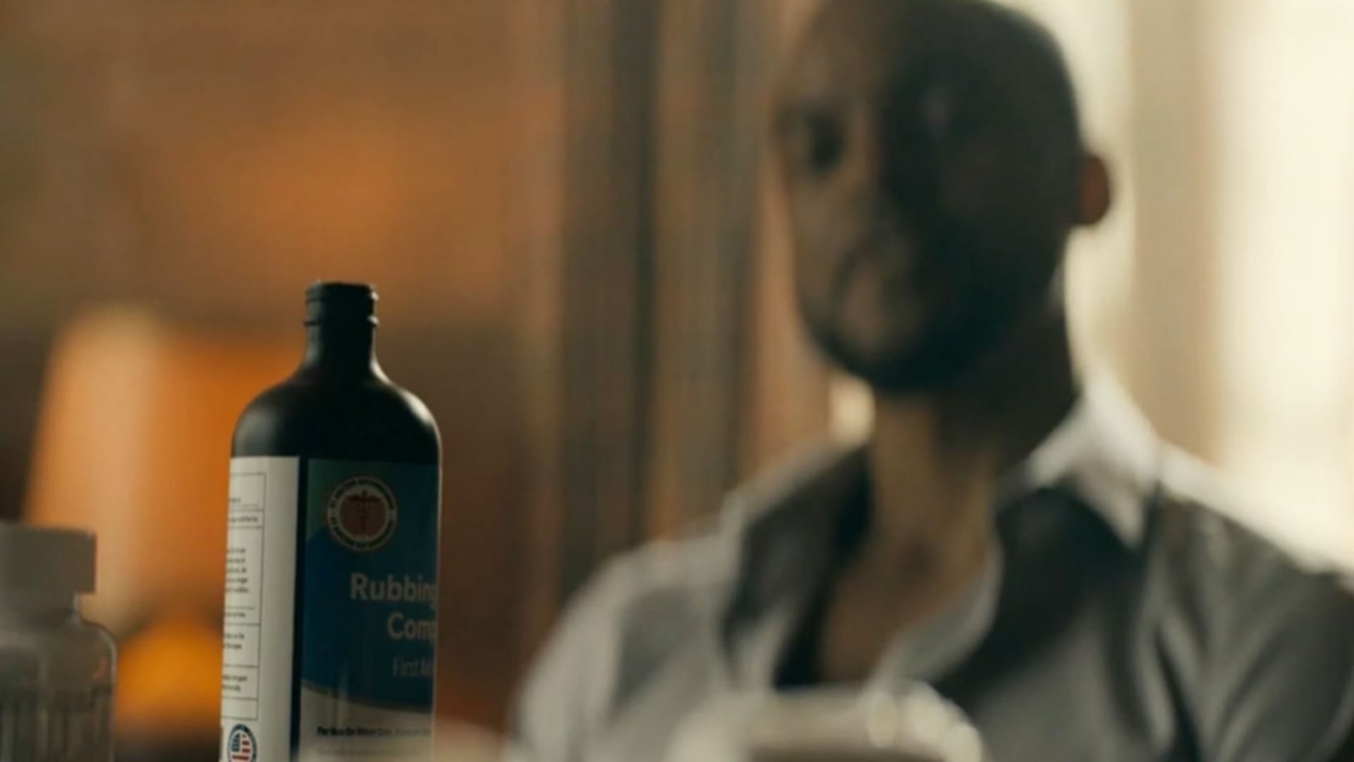 Cooper looks at the bottle of rubbing alcohol in Reacher Season 3 (Image via Prime Video)