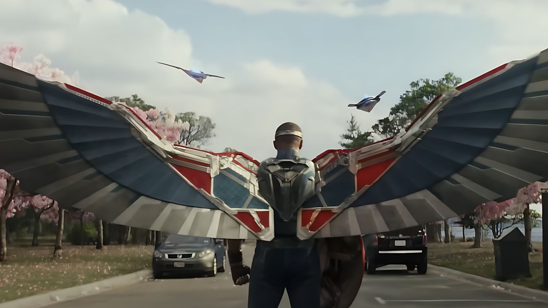 Sam Wilson stands with his metal wings open