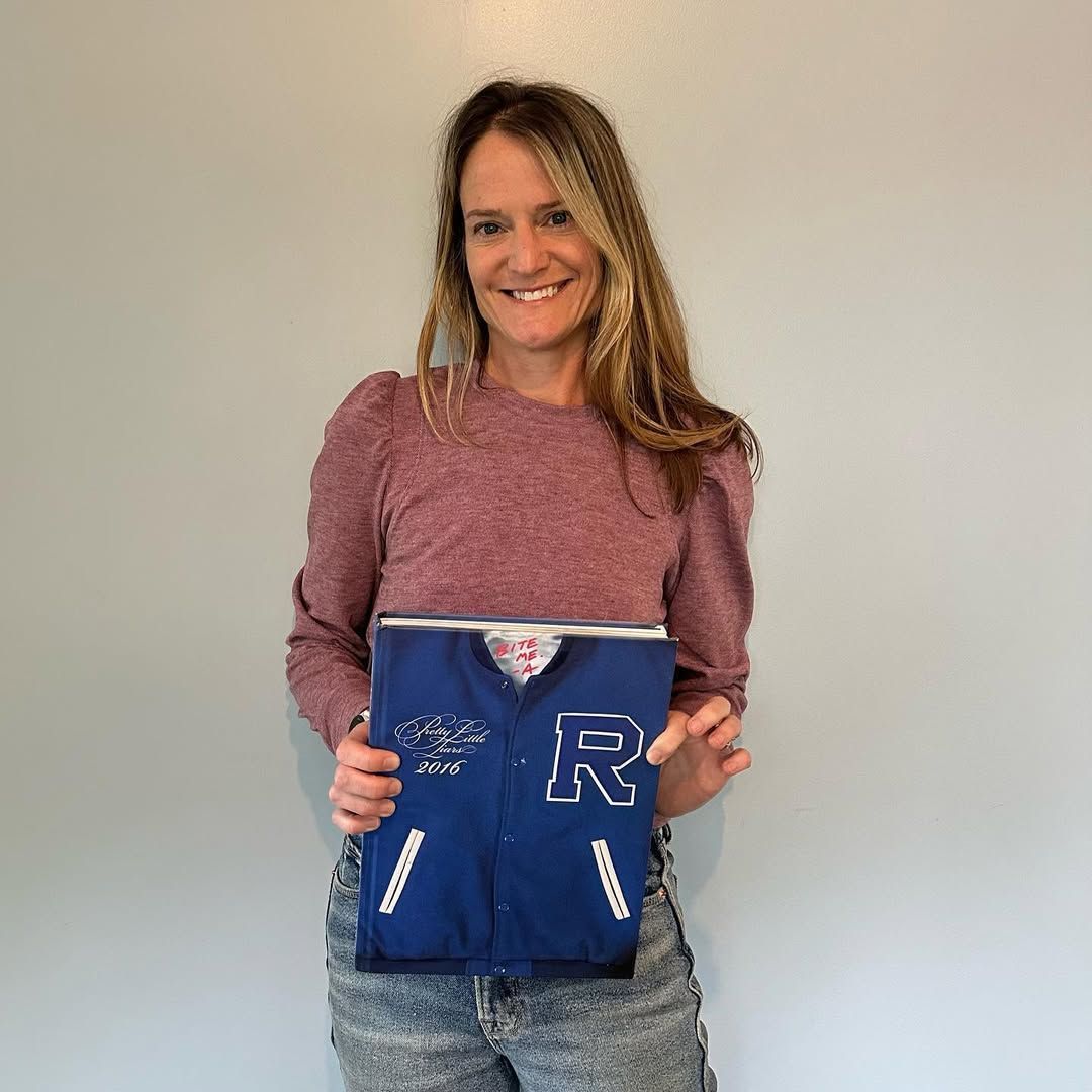 Sara Shepard, the author of Pretty Little Liars, holding the PLL Yearbook (Image via Instagram/saracshepard)