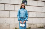 Alix Earle stuns in a light blue vinyl ensemble with Miu Miu accessories at Paris Fashion Week. (Image via Getty/Raimonda Kulikauskiene)