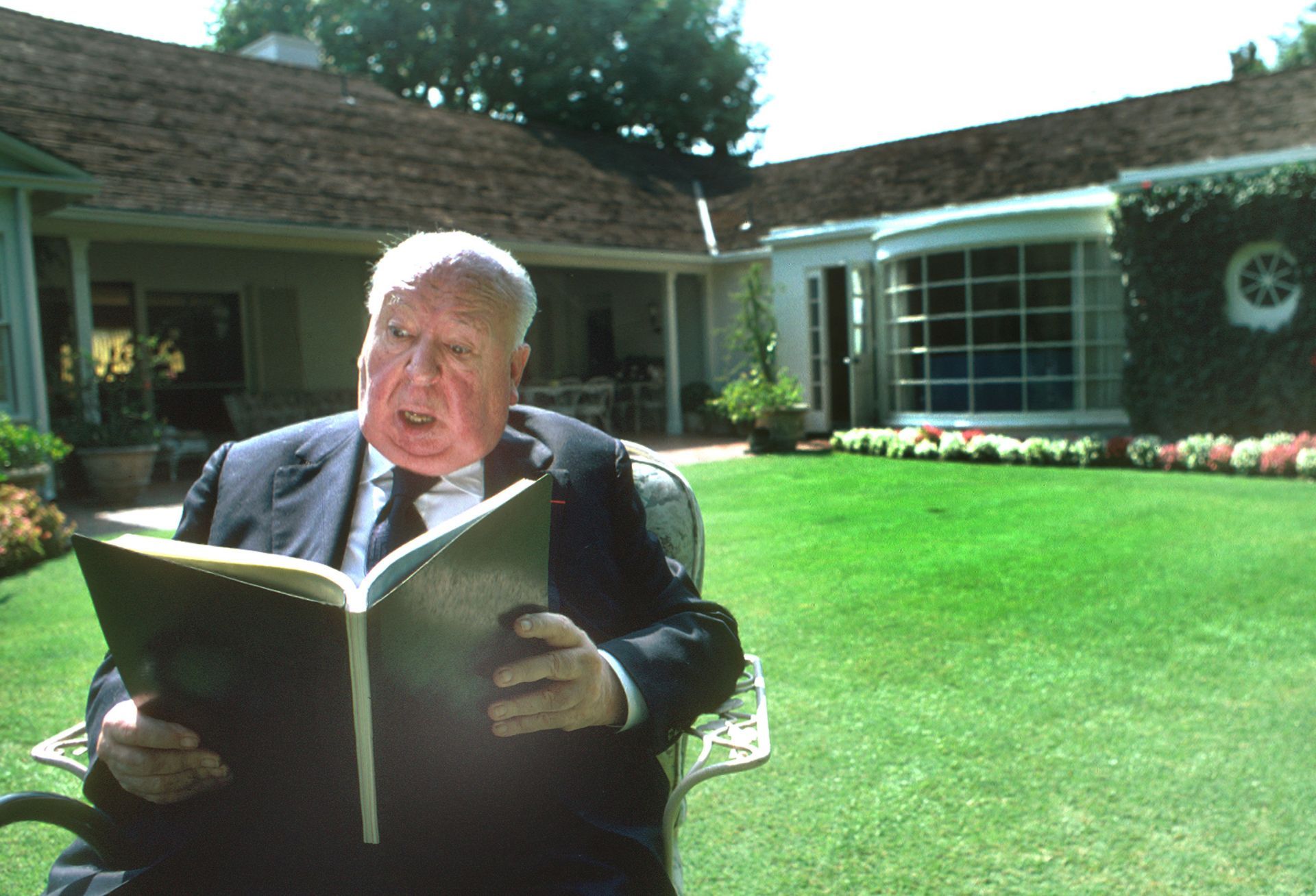 Alfred Hitchcock Reads Outdoors - Source: Getty