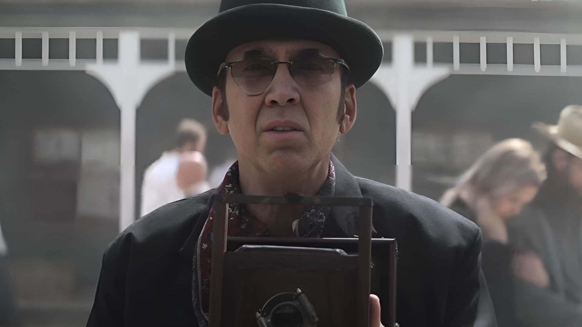 Nicolas Cage standing with a camera in Gunslingers