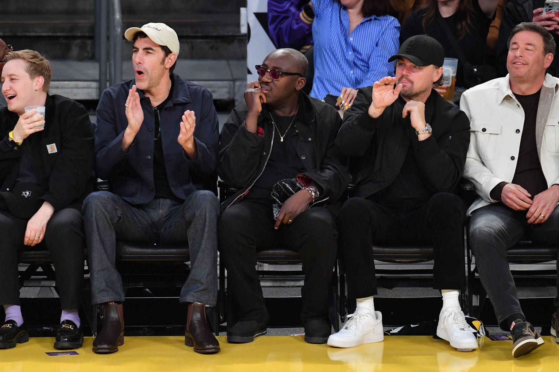 [L-R] Cohen, Enninful, and DiCaprio sitting by the courtside during the Lakers vs Pelicans game on Tuesday (Image via Allen Berezovsky/Getty Images)