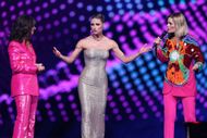 Presenters Michelle Hunziker (M), Hazel Brugger (r), and Sandra Studer take to the stage of the St. Jakobshalle for the final of the 69th Eurovision Song Contest - Source: Getty