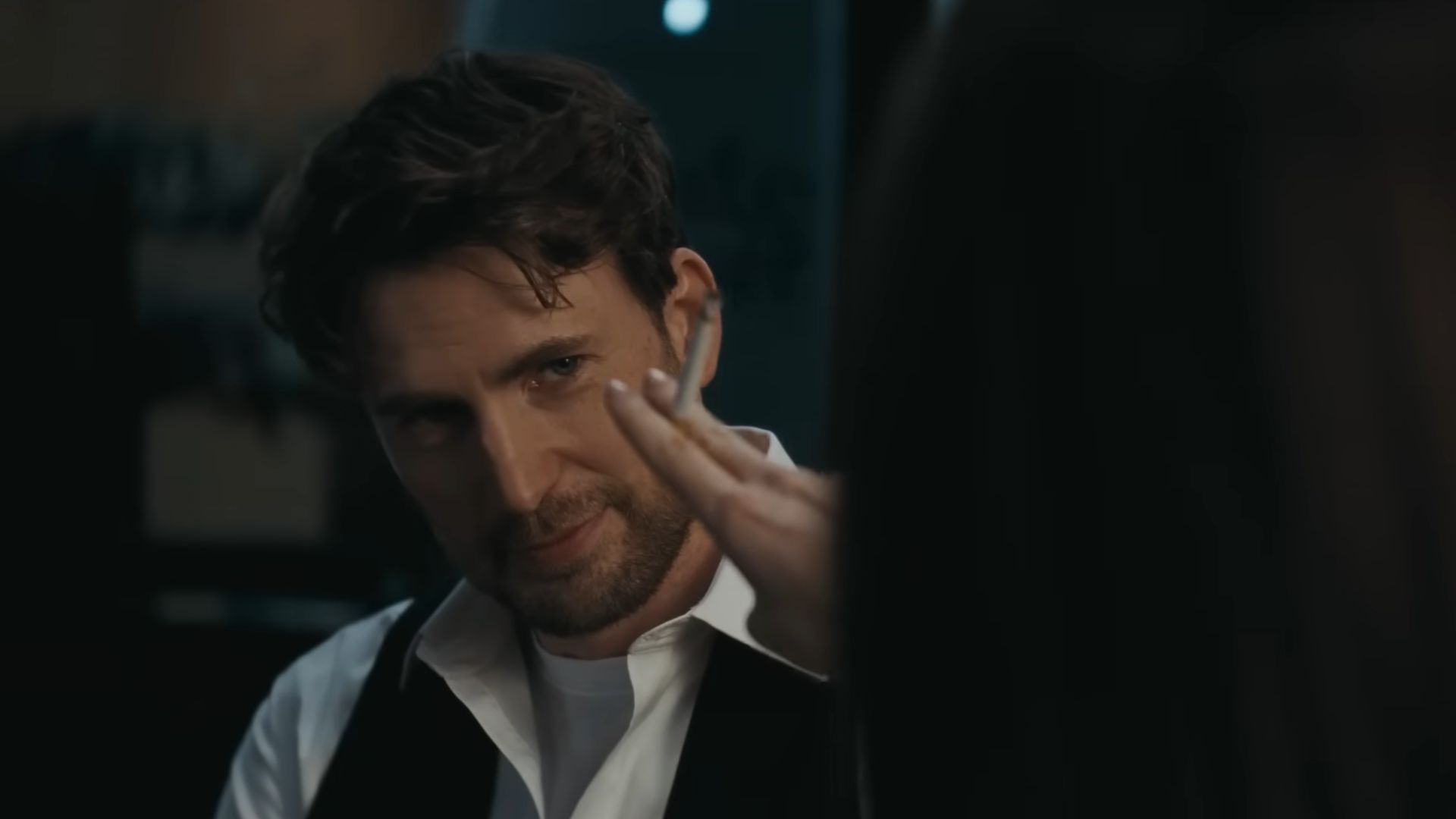 Dakota Johnson offers a cigarette to Chris Evans