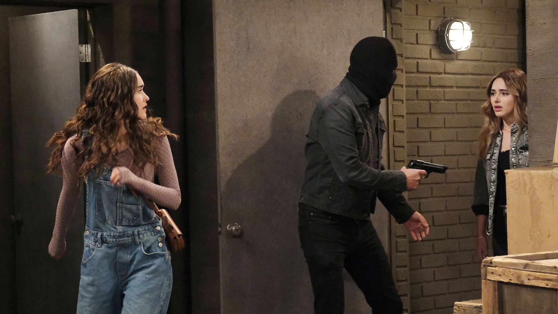 A masked man holds Ari and Holly at gunpoint in a warehouse on Days of our Lives | Image: Peacock