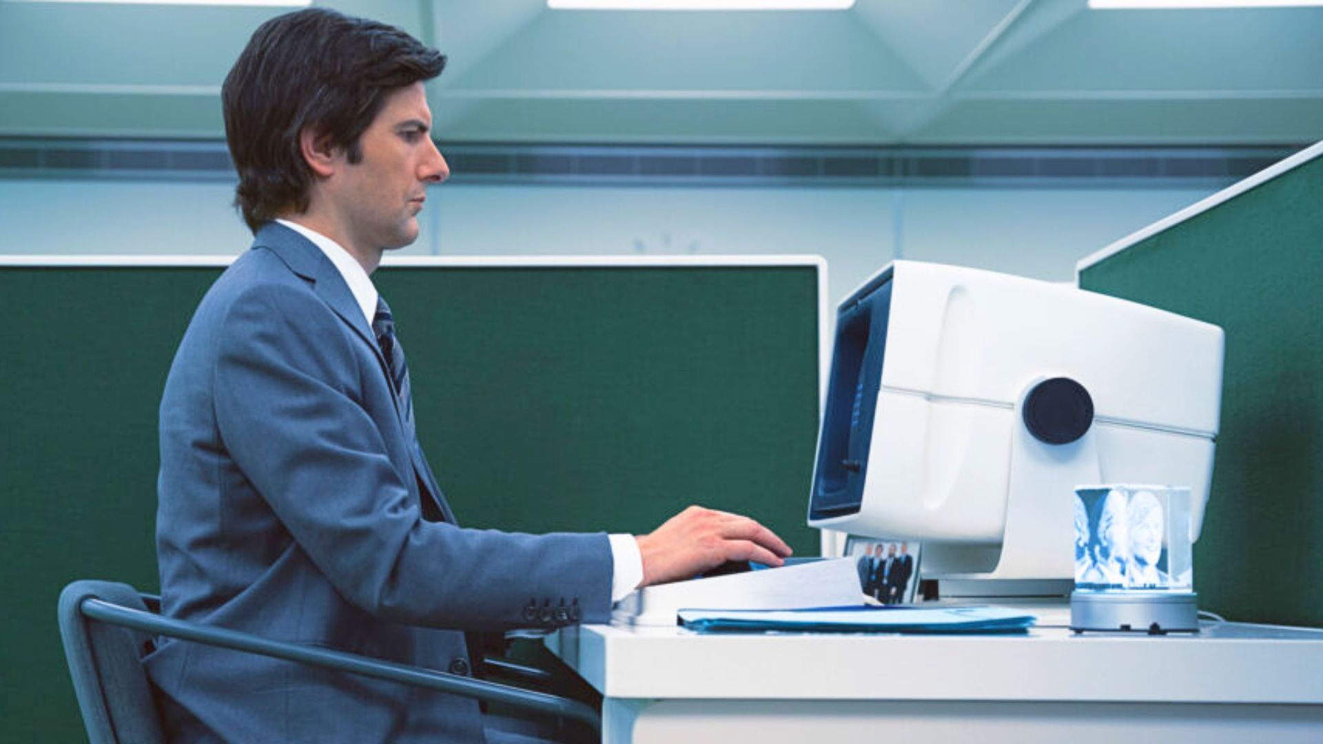 Adam Scott as Mark Scout working at a CRT computer in Lumon&rsquo;s retrofuturistic office in Severance. (Image via Apple TV+)