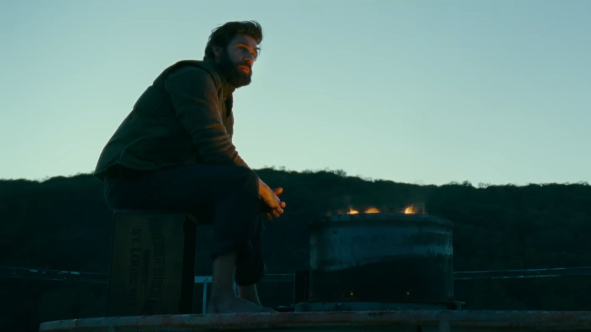 Lee Abbott is sitting on the top of a silo where he is sitting by fire