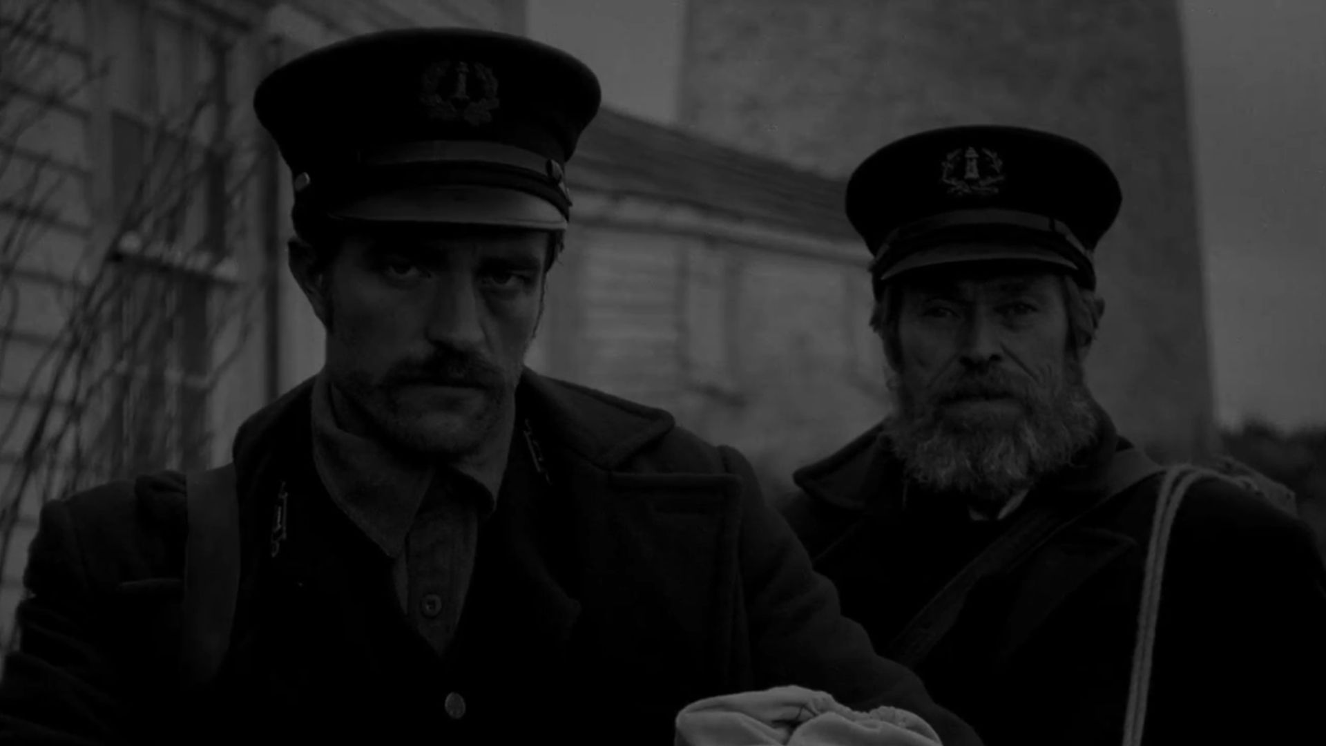 Ephraim Winslow (Robert Pattinson) and Thomas Wake (Willem Dafoe) looking straight at the screen