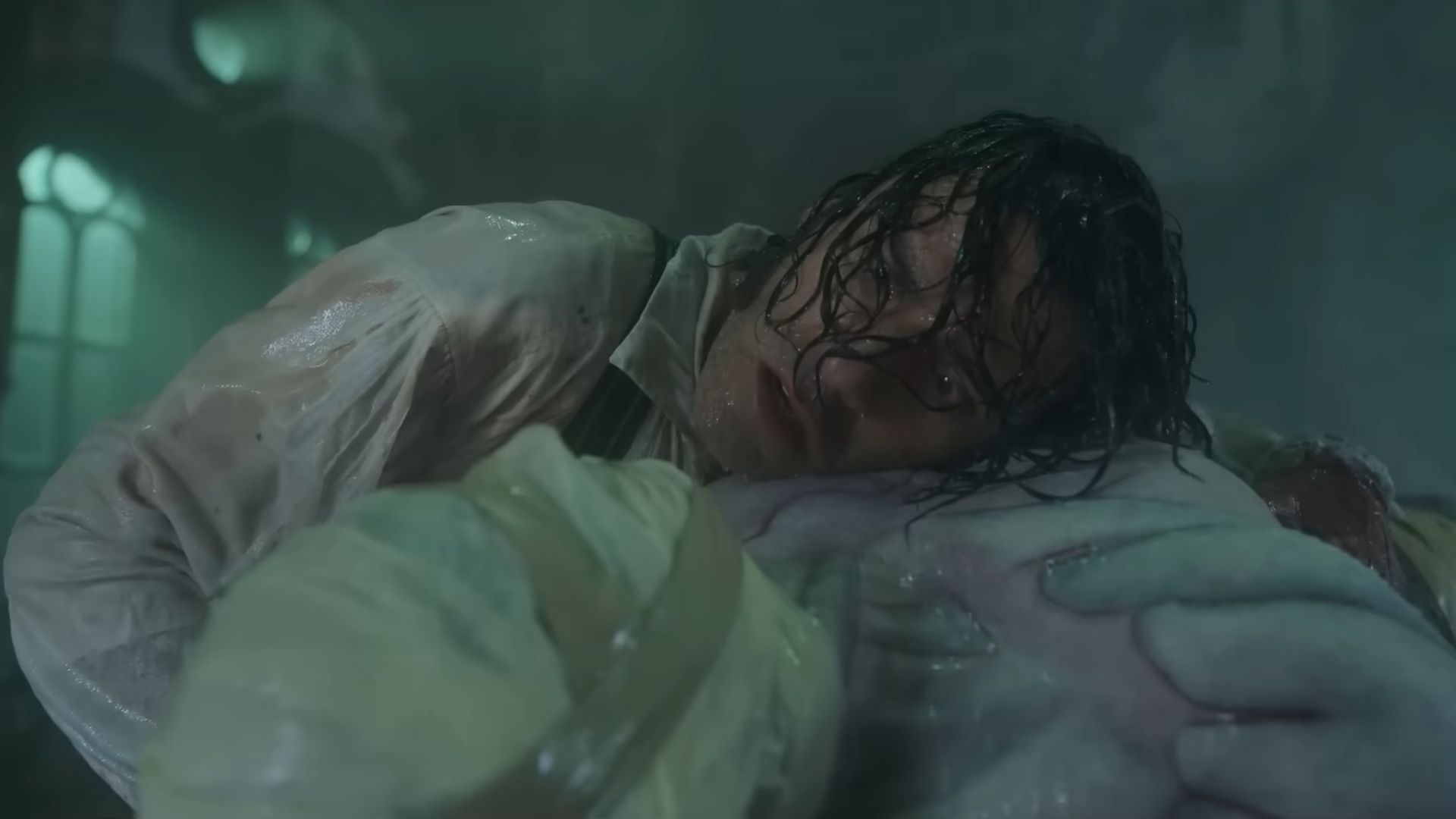 Victor Frankenstein (Oscar Isaac) appears to be listening to the heartbeat of the creature wrapped in bandages