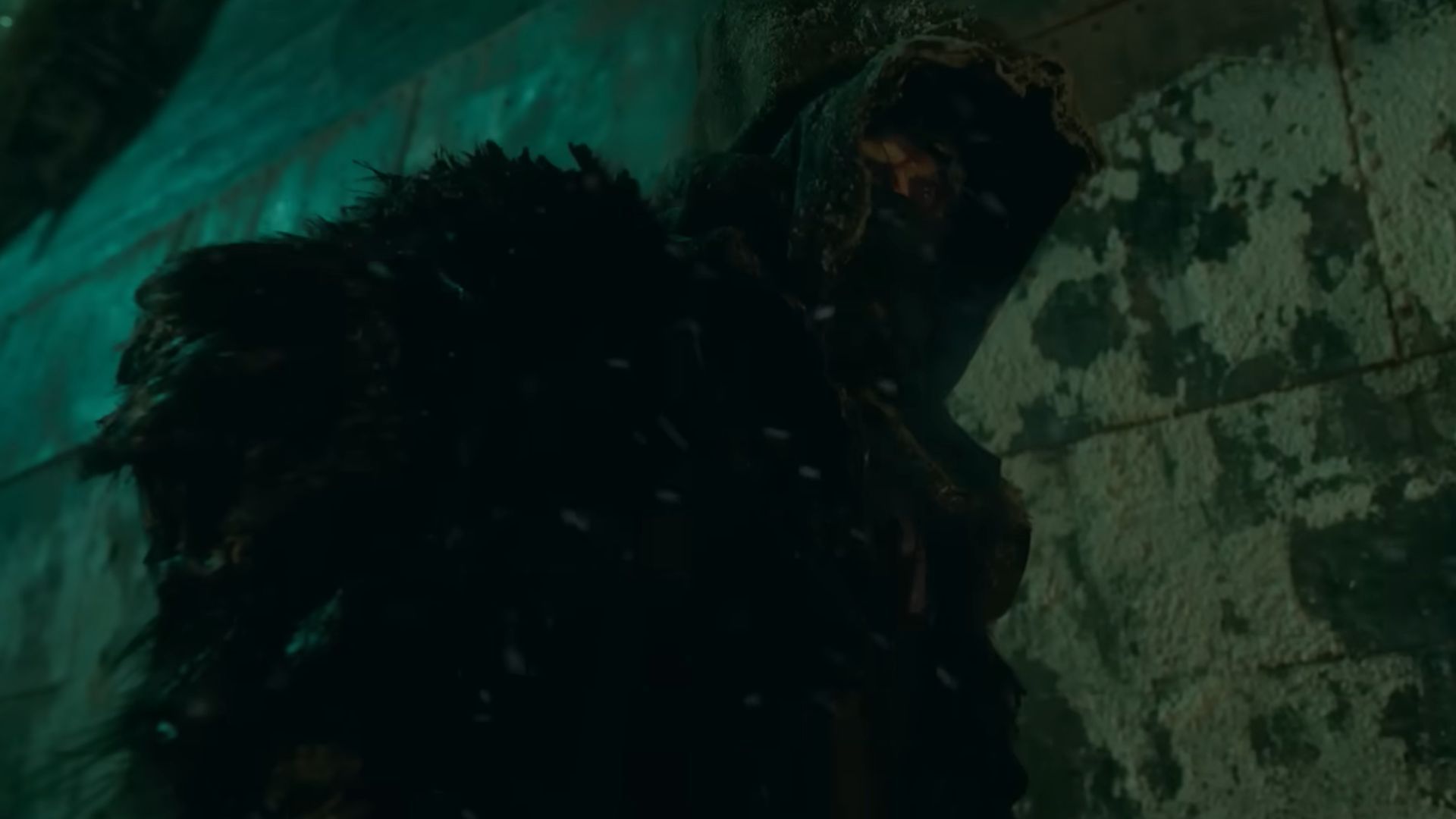 The Creature (Jacob Elordi) stands in snow with a ship in the background