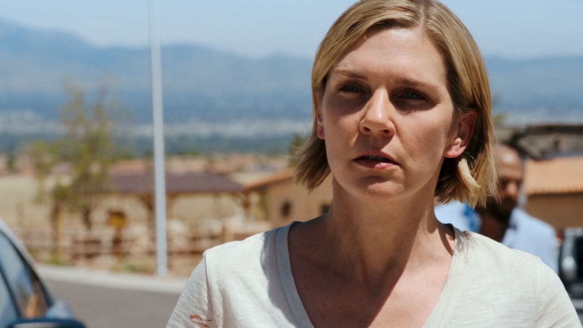 Carol (Rhea Seehorn) in a white t-shirt looking at someone in surprise