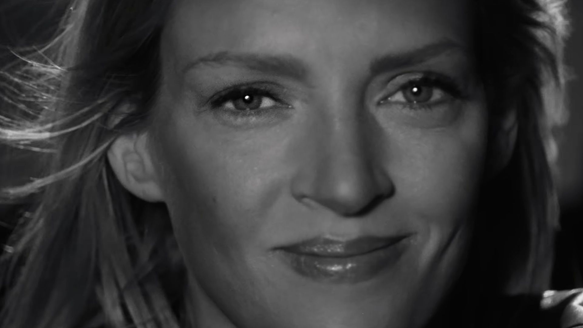 The Bride (Uma Thurman) smiles at the camera.