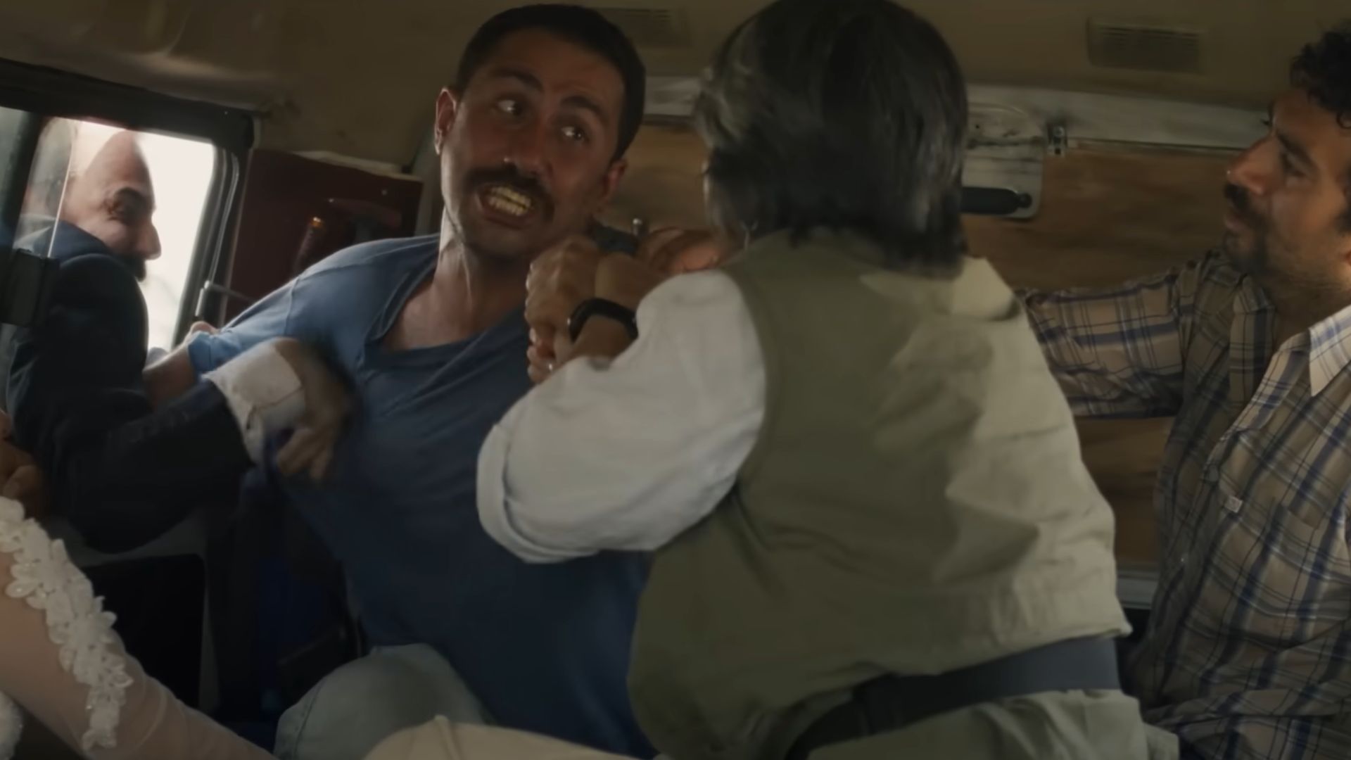 People trying to calm down one man in a van who is trying to kill another man