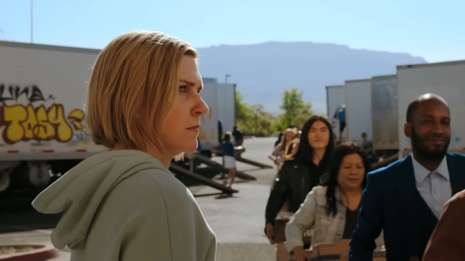 Carol (Rhea Seehorn) watches people go in a queue