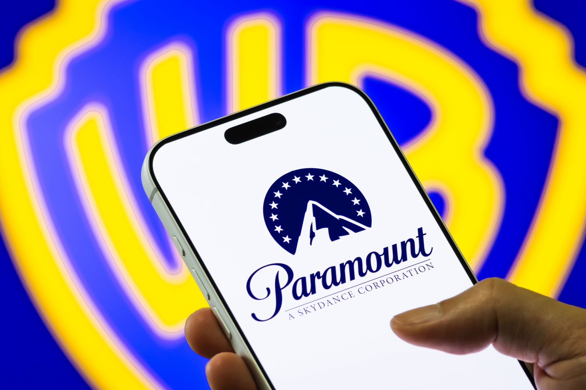 Paramount Logo on Smartphone Against Warner Bros. Discovery Background - Source: Getty