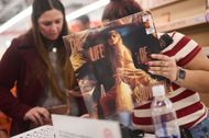Fans browsing through the new Taylor Swift album at a record store (Image via Getty)