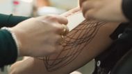 Louise making the tattoo on Rebecca's arm (Image via YouTube/@Apple TV)