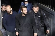Former kickboxer Andrew Tate (L) and his brother Tristan (2nd R) leave court with police cars after their trial in Bucharest, Romania on February 01, 2023 - Source: Getty