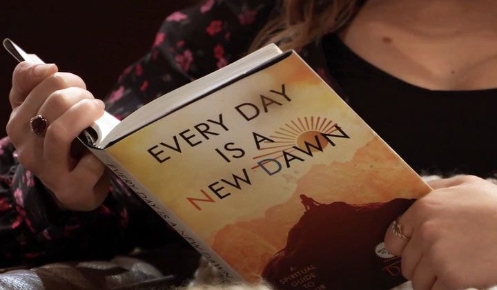 Kristina reads a copy of Every Day Is A New Dawn